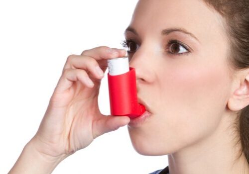 Pretty girl holding asthma inhaler